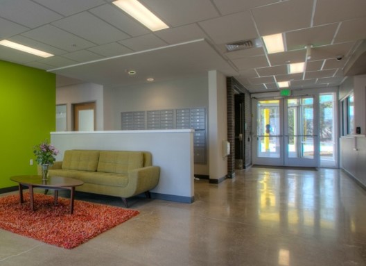 The entryway at Redtail Ponds featuring a seating area with a green couch in a modern style.
