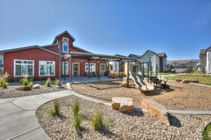 Red barn-inspired clubhouse next to a new playground