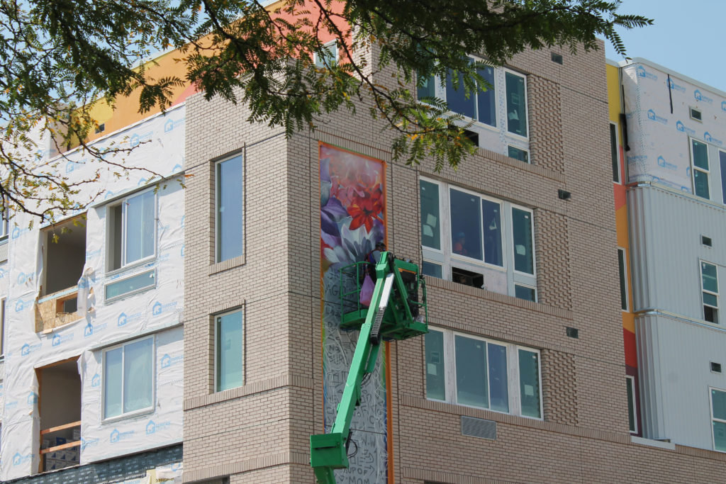 Artist Noé installs murals at Oak 140 Housing Catalyst