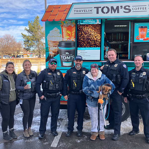 Uniformed officers and residents stand in front of a coffee truck in the Mason Place parking lot.