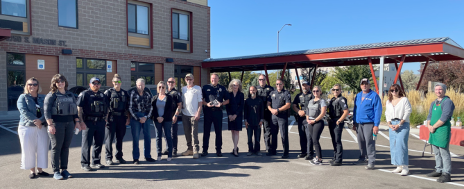 Group of police officers Housing Catalyst staff, and residents stand in front of Mason Place